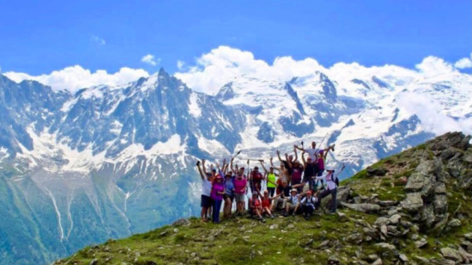 Alpine-1-960x540 A group of people standing on top of a mountain.