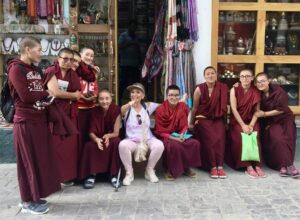 Suzy Davis with monks A group of people in robes and hats posing for the camera.